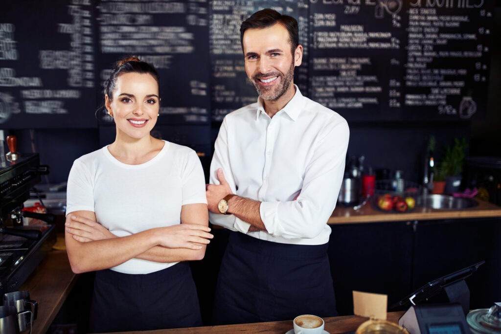 Successful small business partners standing together in cafe